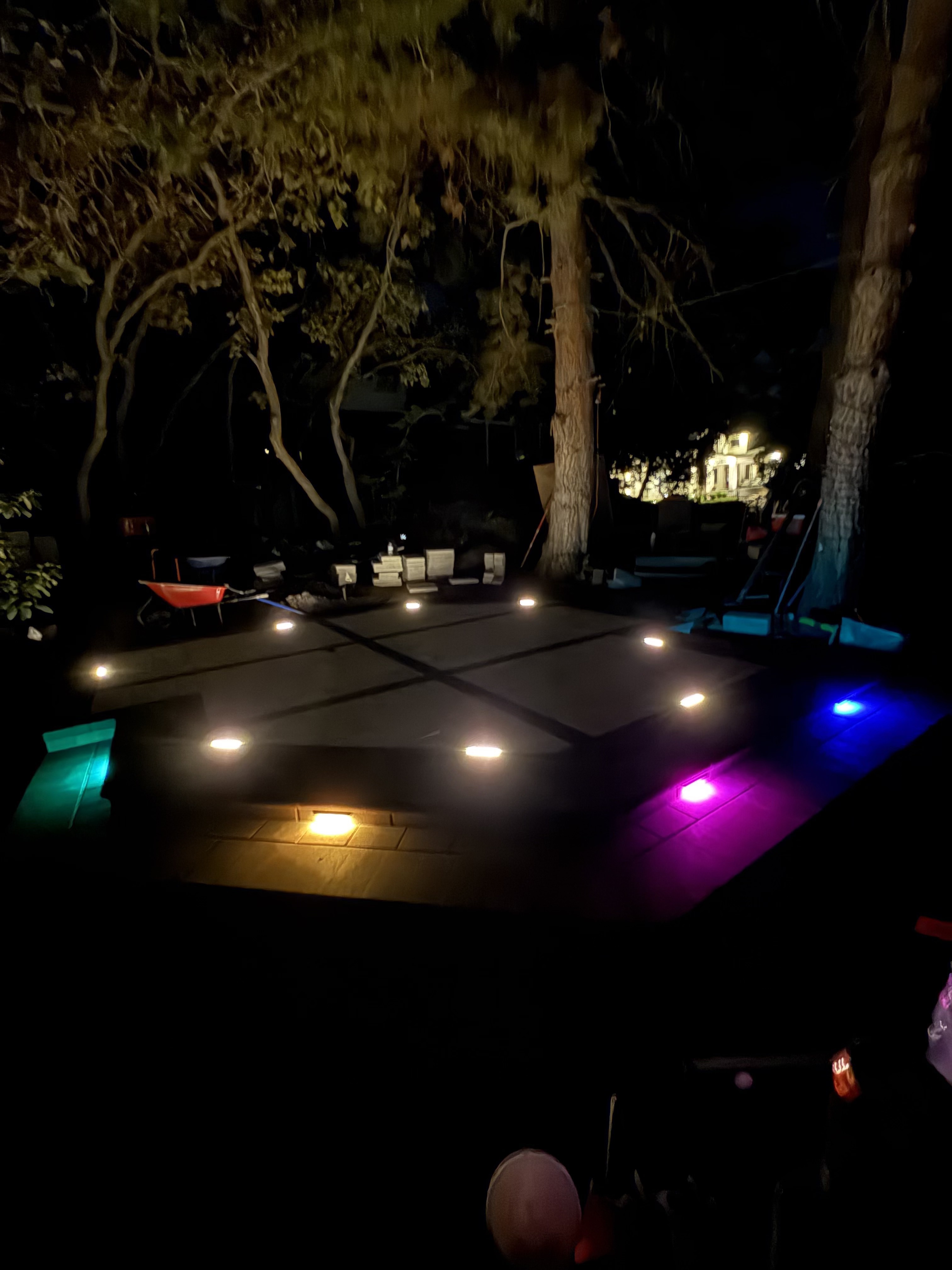 Paver patio at night with multi color RGB underglow lighting