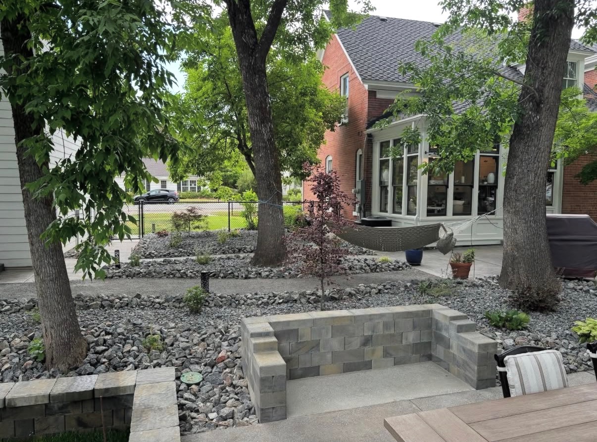Xeriscape backyard with raised brick block planter and rock beds