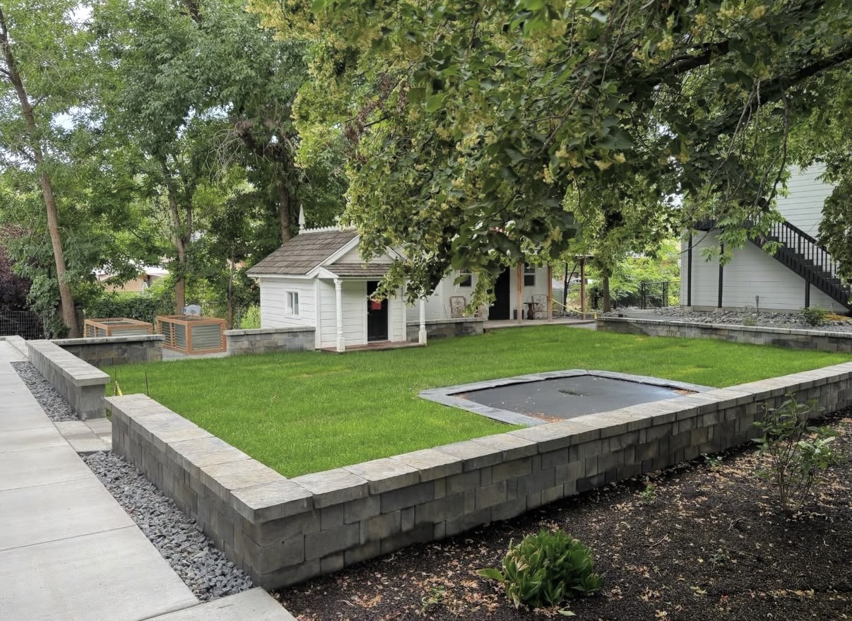 Block retaining wall enclosing a level lawn area