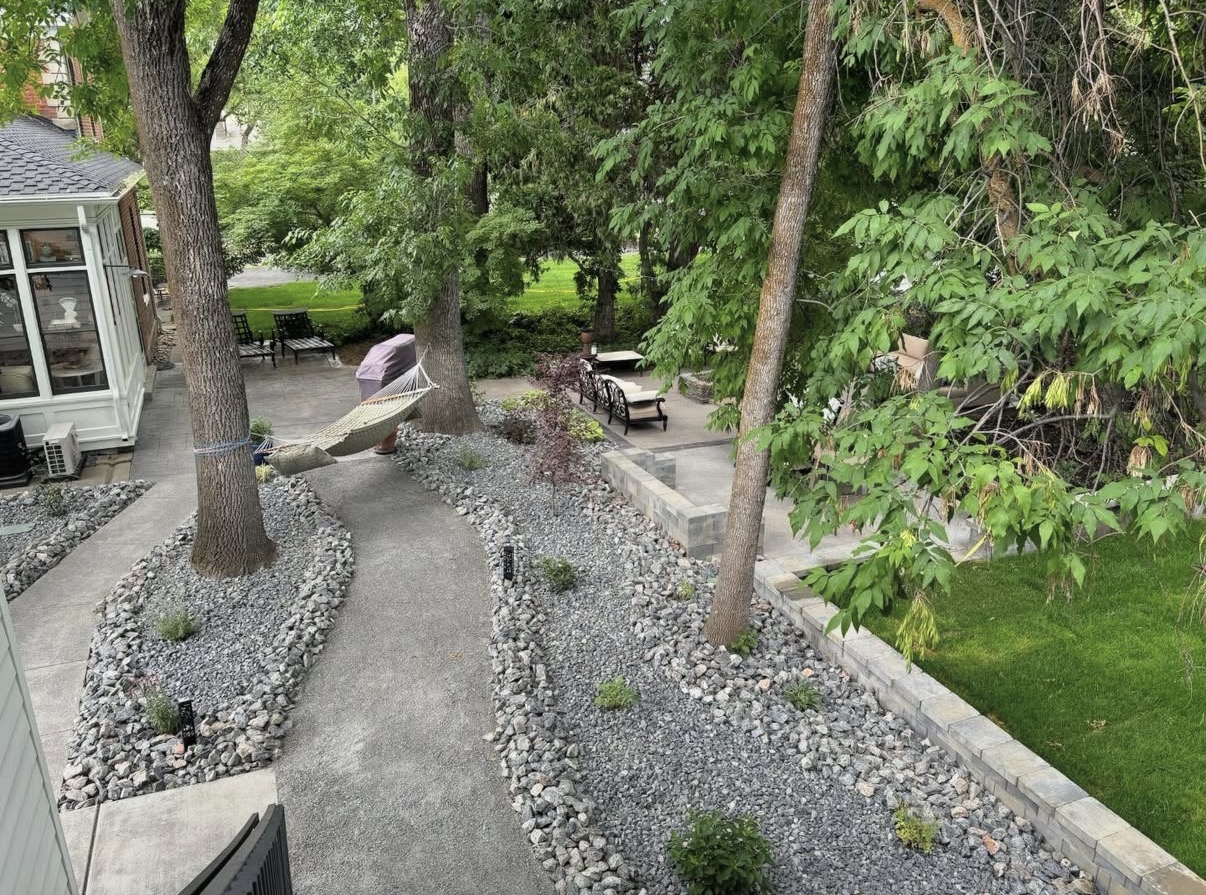 Backyard xeriscape with rock river bed walkways and hammock