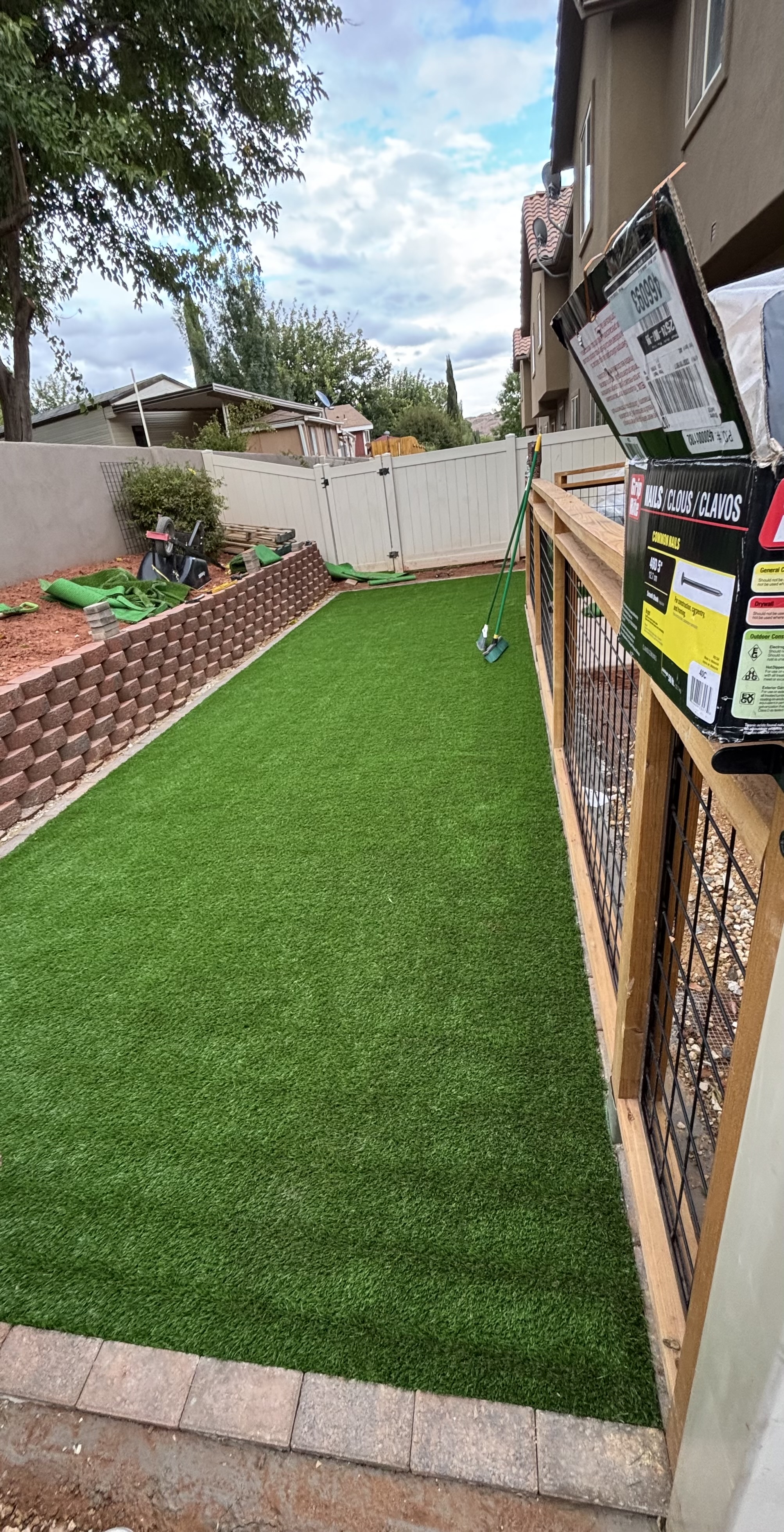 Side yard synthetic turf strip with brick block edging