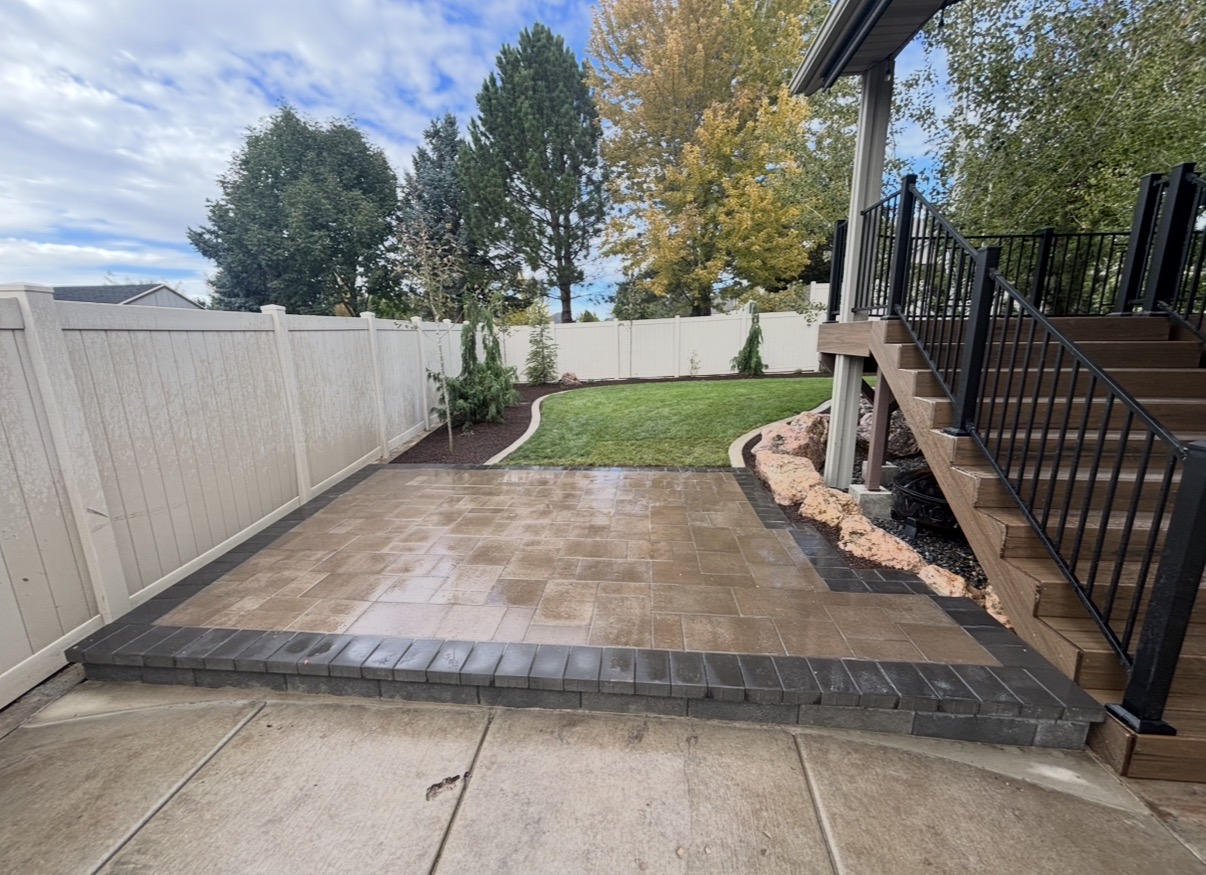 Paver patio with contrasting banding next to deck