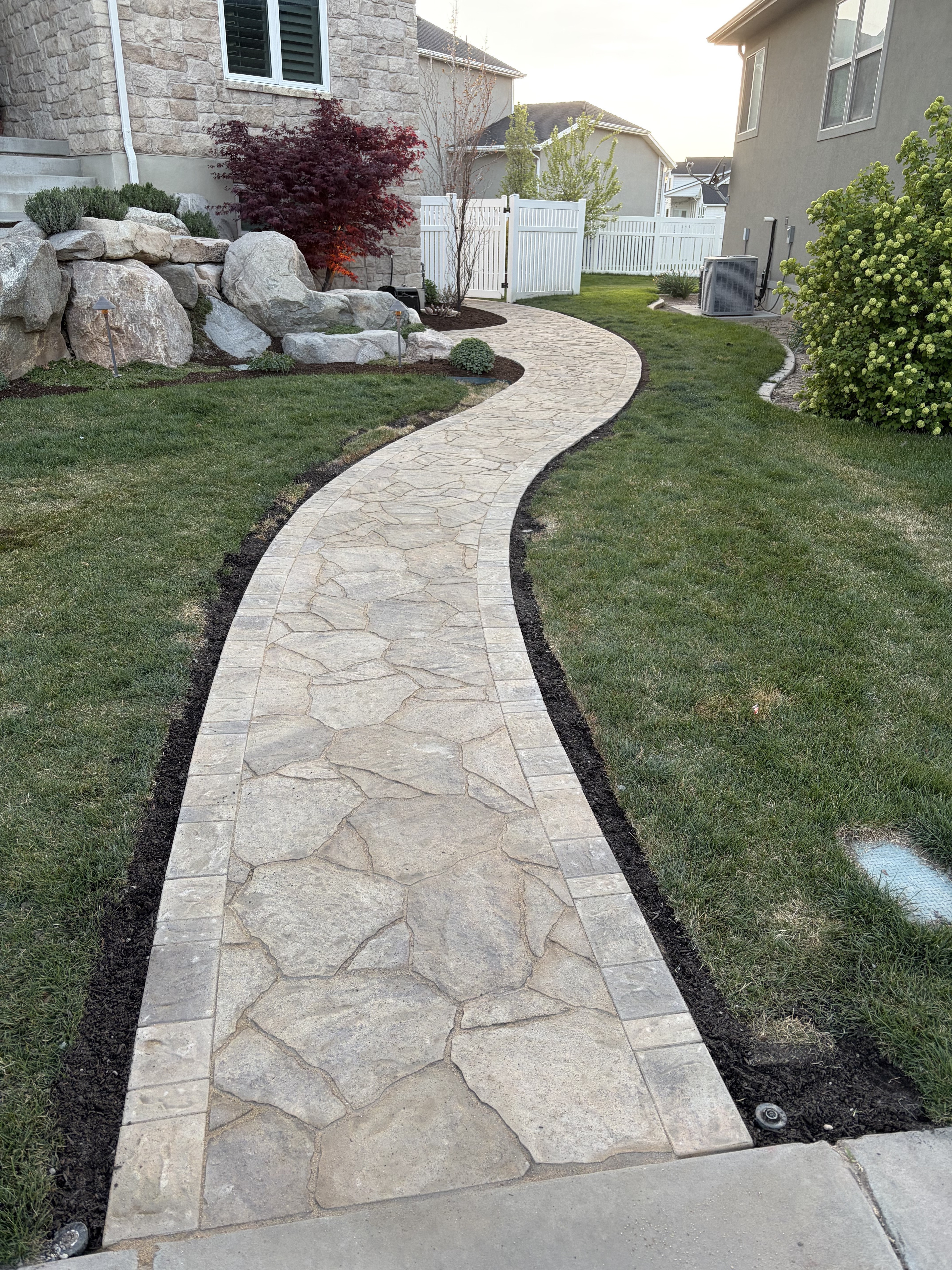 Curved natural stone walkway with paver banding