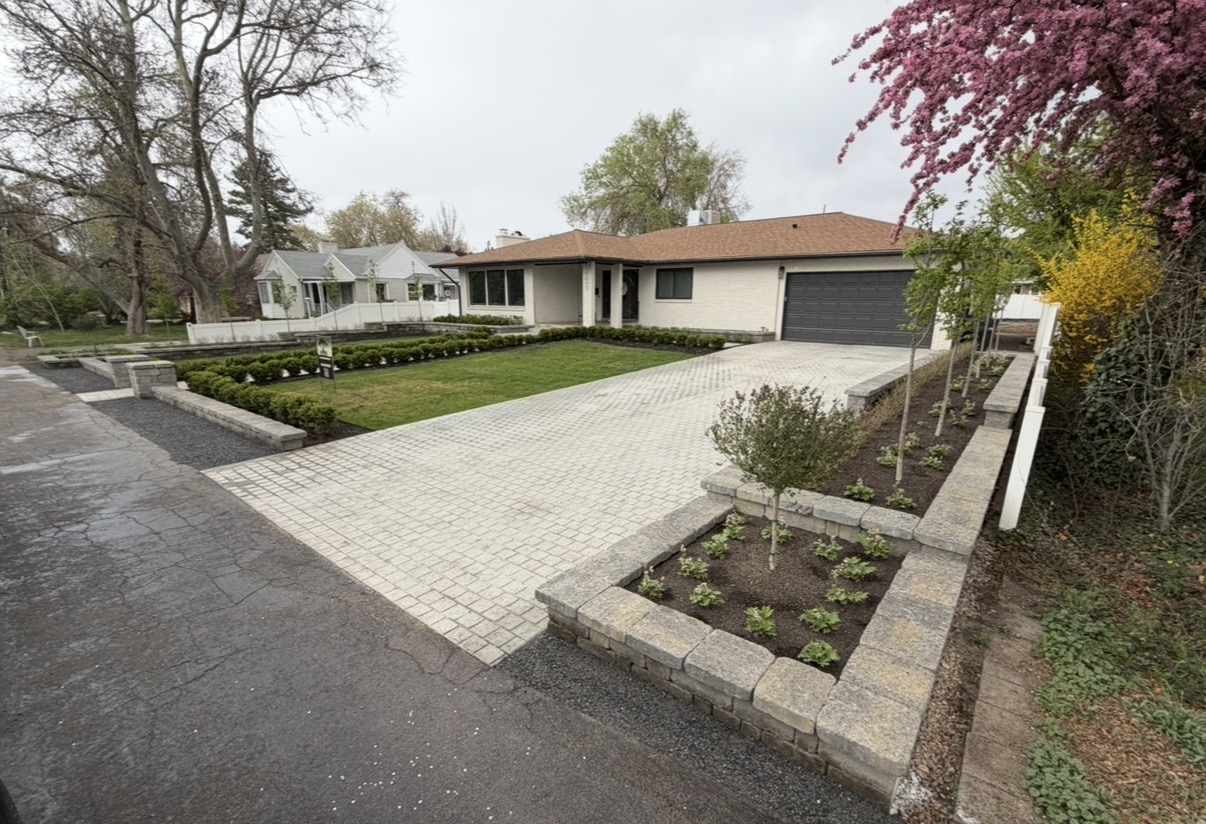Paver driveway with planter beds at modern home