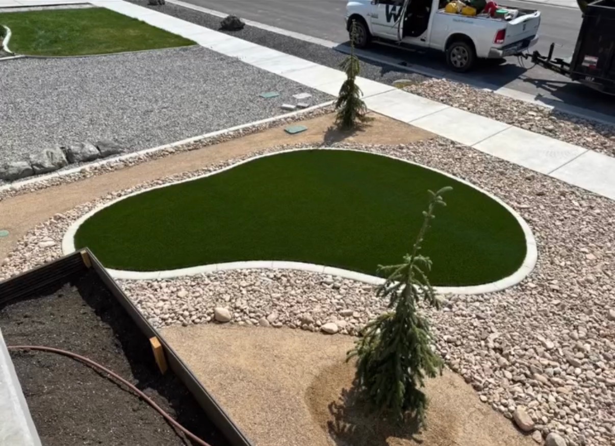 Front yard kidney shaped synthetic turf island with rock surround